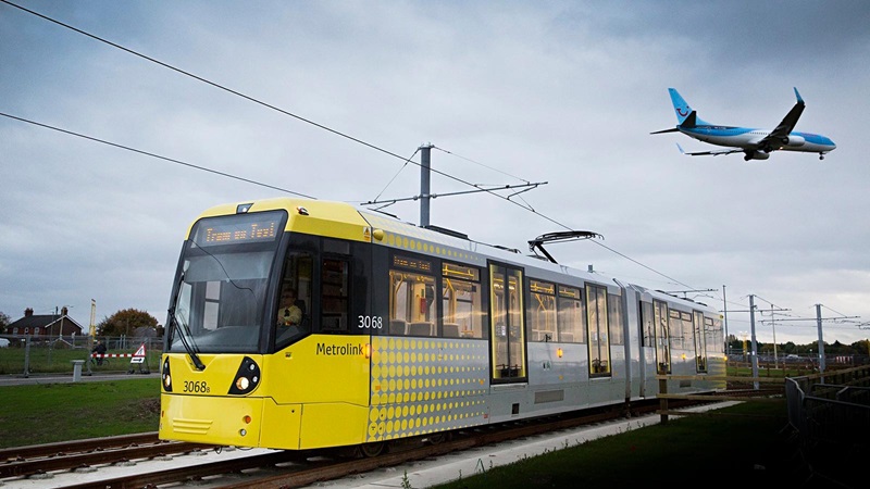 Blue Tui Plane Flying Over a Yellow Tram - Mace Group