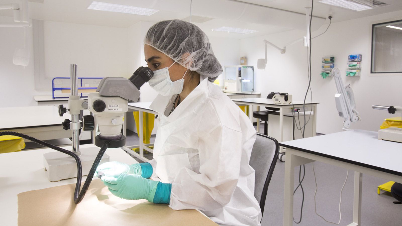 Female Lambeth Forensic Staff in Laboratory Using a Microscope - Mace Group