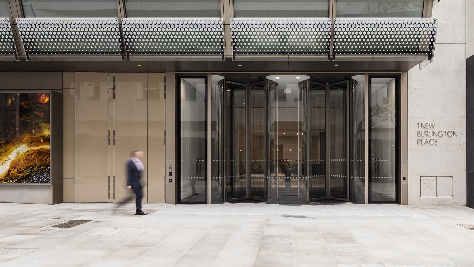 Person Walking in Front of W5 – New Burlington Place Building - Mace Group